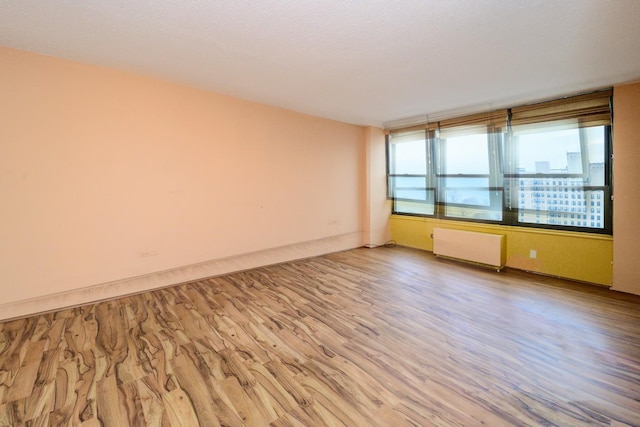 5471 S Hyde Park Blvd Unit 16Ab, Chicago, IL 60615 - spare room featuring radiator heating unit and wood finished floors