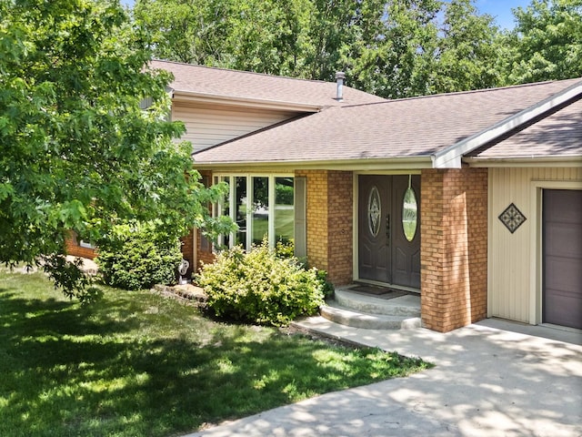 1106 Countryside Ln, Pontiac, IL 61764 - doorway to property featuring a shingled roof, brick siding, and a lawn