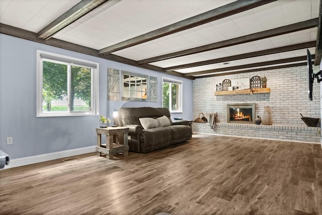 1106 Countryside Ln, Pontiac, IL 61764 - living room with beamed ceiling, wood finished floors, a fireplace, and brick wall
