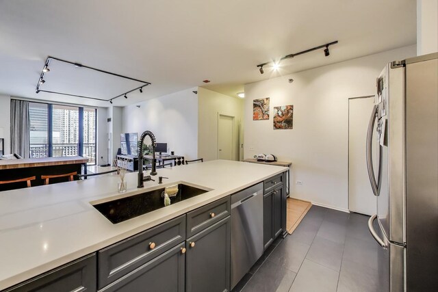 330 N Jefferson St Unit 903, Chicago, IL 60661 - kitchen with stainless steel appliances, rail lighting, light countertops, dark tile patterned flooring, and open floor plan
