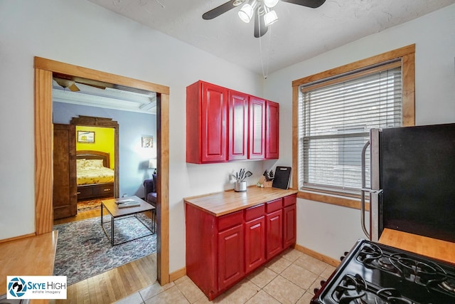 945 E Hyde Park Blvd Unit 2, Chicago, IL 60615 - kitchen with freestanding refrigerator, ceiling fan, black range with gas stovetop, reddish brown cabinets, and light tile patterned floors