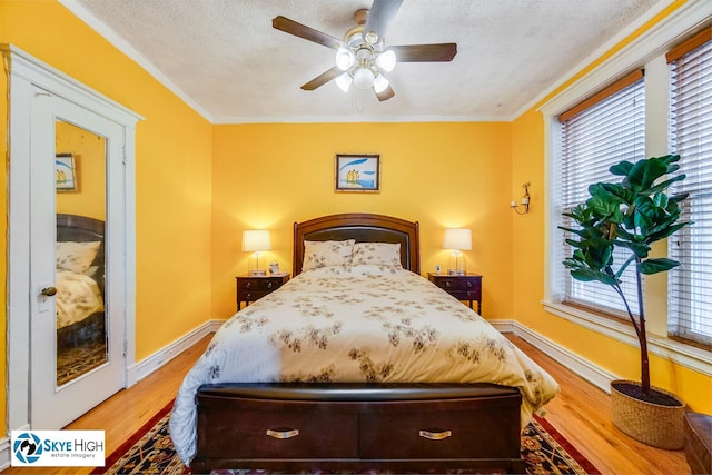 945 E Hyde Park Blvd Unit 2, Chicago, IL 60615 - bedroom with wood finished floors, multiple windows, a textured ceiling, a ceiling fan, and crown molding