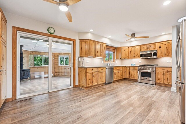 42280 N Center St, Antioch, IL 60002 - kitchen with stainless steel appliances, ceiling fan, a wood stove, light wood-type flooring, and baseboard heating