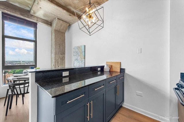 1550 S Blue Island Ave Unit 822, Chicago, IL 60608 - kitchen featuring light wood-type flooring, plenty of natural light, a peninsula, and dark stone counters