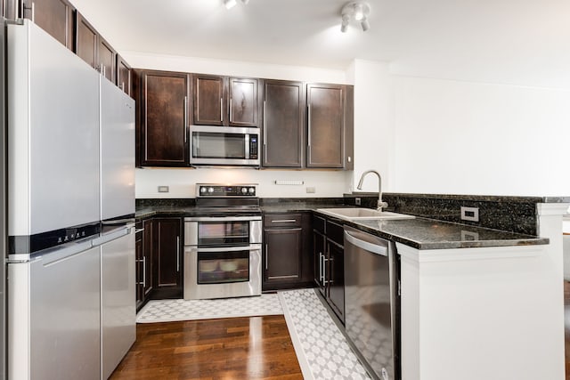 1901 S Calumet Ave Unit 2010, Chicago, IL 60616 - kitchen with appliances with stainless steel finishes, a peninsula, dark wood-style floors, dark brown cabinetry, and dark stone countertops