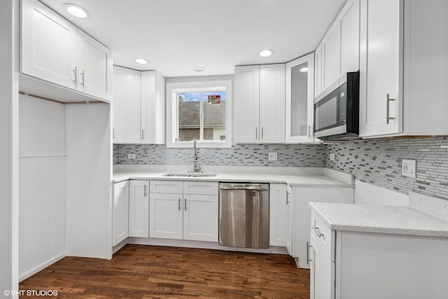 629 E 87th Pl, Chicago, IL 60619 - kitchen featuring appliances with stainless steel finishes, backsplash, glass insert cabinets, white cabinetry, and dark wood-style floors