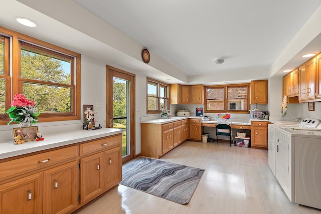kitchen featuring washing machine and clothes dryer, light wood-style floors, light countertops, recessed lighting, and brown cabinets