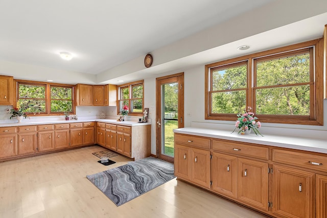 kitchen with light wood finished floors, light countertops, and brown cabinetry