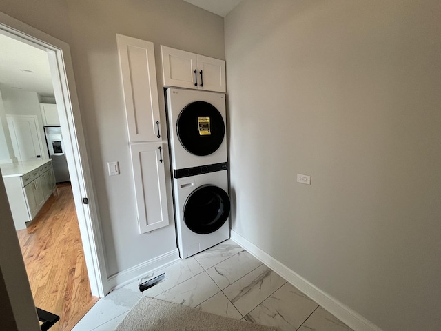1266 Airs Ave, Sugar Grove, IL 60554 - laundry area featuring cabinet space, stacked washer and clothes dryer, and light marble finish flooring