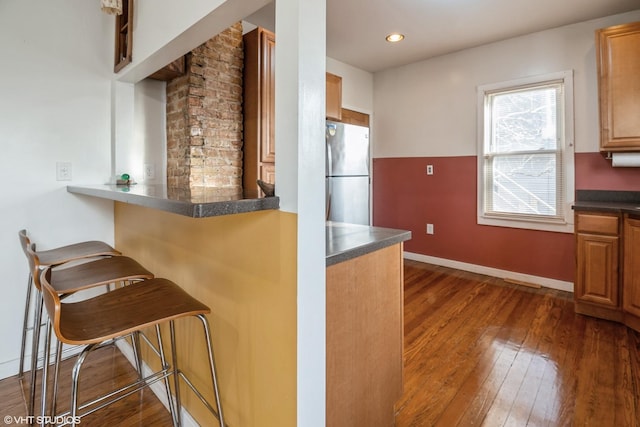 120 S Kinzie St, Thornton, IL 60476 - kitchen with freestanding refrigerator, dark wood-type flooring, a kitchen breakfast bar, dark countertops, and recessed lighting