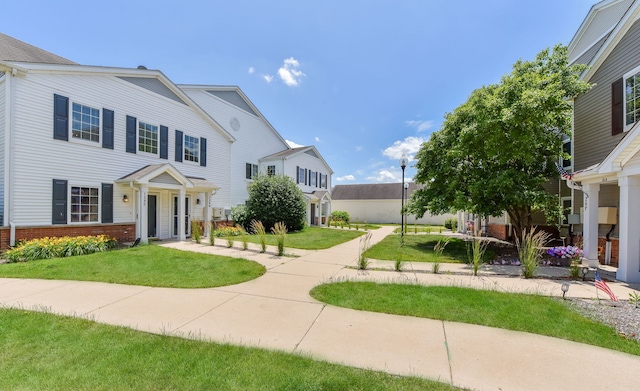 128 Bertram Dr Unit M, Yorkville, IL 60560 - view of front of house featuring brick siding and a front yard