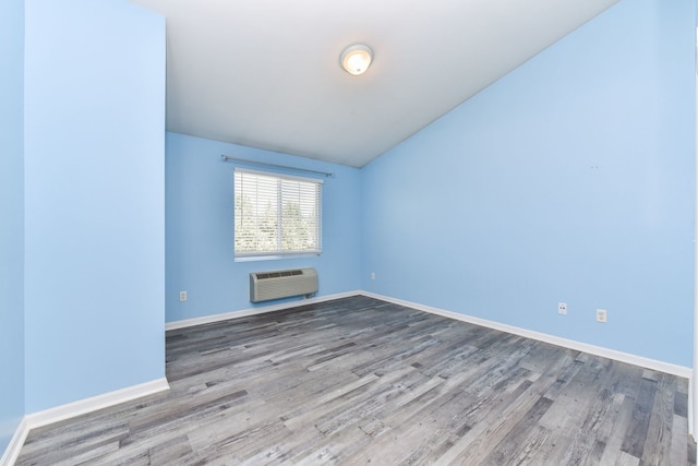128 Bertram Dr Unit M, Yorkville, IL 60560 - spare room featuring an AC wall unit, wood finished floors, and vaulted ceiling