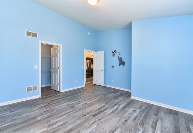 128 Bertram Dr Unit M, Yorkville, IL 60560 - unfurnished bedroom featuring wood finished floors, stainless steel refrigerator with ice dispenser, a closet, and a spacious closet