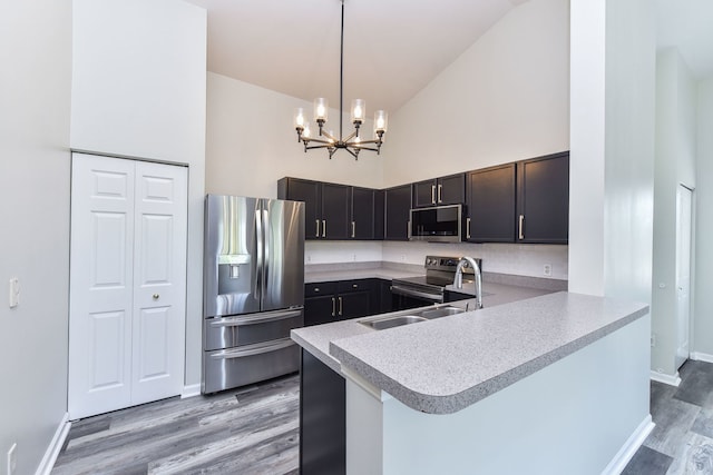 128 Bertram Dr Unit M, Yorkville, IL 60560 - kitchen featuring stainless steel appliances, light wood-style floors, high vaulted ceiling, light countertops, and a peninsula