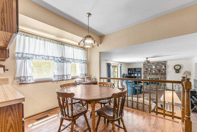 1707 Roosa Ln, Elk Grove Village, IL 60007 - dining room with wood finished floors, ceiling fan, and a brick fireplace