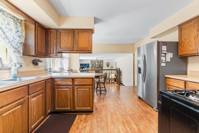 1707 Roosa Ln, Elk Grove Village, IL 60007 - kitchen with light wood-type flooring, brown cabinets, light countertops, and a peninsula
