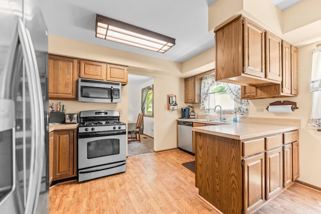 1707 Roosa Ln, Elk Grove Village, IL 60007 - kitchen with stainless steel appliances, a peninsula, light countertops, and light wood-style floors
