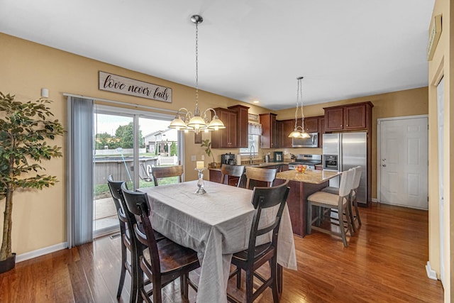 504 W Hillcrest Dr, Romeoville, IL 60446 - dining area featuring healthy amount of natural light, dark wood-style floors, and a chandelier