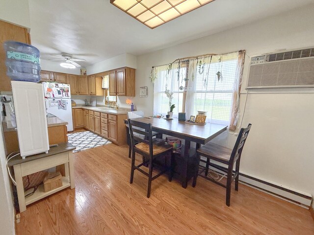 31535 E Thome Rd, Rock Falls, IL 61071 - dining space featuring an AC wall unit, light wood-style flooring, ceiling fan, and baseboard heating