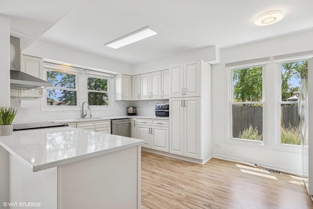 4315 Lombardy Ln, Hoffman Estates, IL 60192 - kitchen with stainless steel dishwasher, wall chimney exhaust hood, decorative backsplash, light wood-style flooring, and white cabinetry
