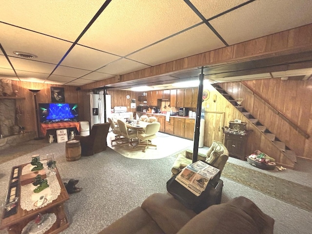 312 Water St, Earlville, IL 60518 - finished basement featuring wooden walls, a paneled ceiling, carpet, stairway, and stainless steel fridge