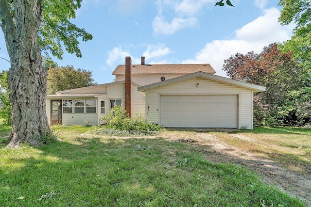 33049 S Symerton Rd, Wilmington, IL 60481 - view of front of home with dirt driveway, a chimney, a front yard, and a garage