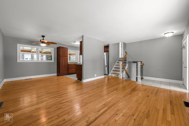 36665 N Traer Ter, Gurnee, IL 60031 - unfurnished living room with light wood-style flooring, a ceiling fan, and stairs