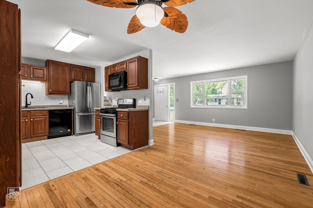 36665 N Traer Ter, Gurnee, IL 60031 - kitchen with black appliances, a ceiling fan, light wood-style floors, light countertops, and open floor plan