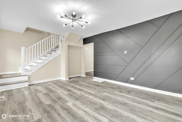9613 S Yale Ave, Chicago, IL 60628 - unfurnished living room with wood finished floors, a chandelier, stairway, and a decorative wall