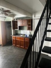 829 E 48th St Unit D, Chicago, IL 60615 - kitchen with open shelves, dark countertops, concrete flooring, brown cabinetry, and a ceiling fan