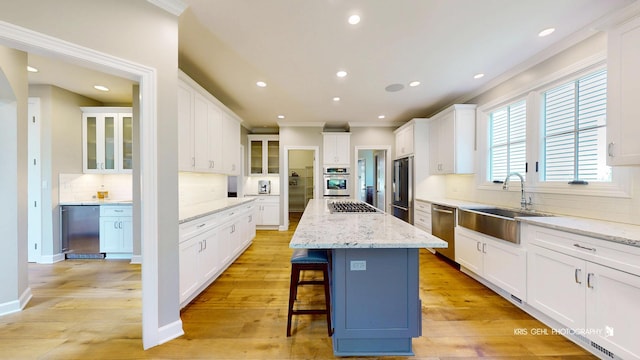 905 Burnham Ct, Aurora, IL 60502 - kitchen with stainless steel appliances, crown molding, a center island, decorative backsplash, and a breakfast bar area