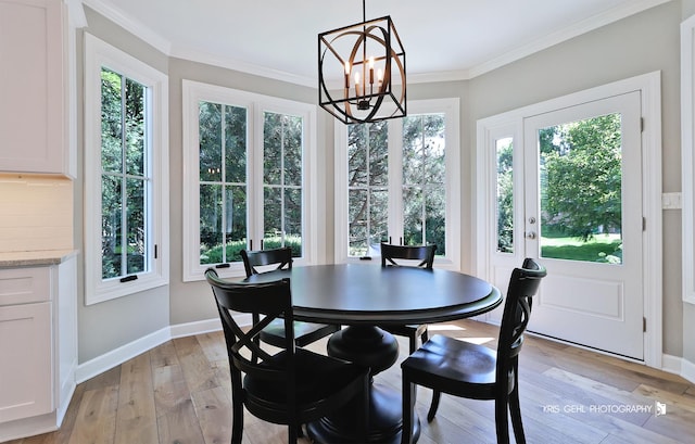 905 Burnham Ct, Aurora, IL 60502 - dining area featuring plenty of natural light, a chandelier, light wood-type flooring, and ornamental molding