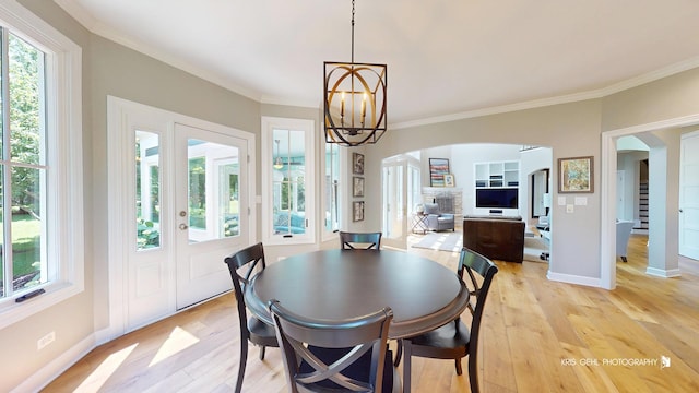 905 Burnham Ct, Aurora, IL 60502 - dining room featuring arched walkways, light wood-type flooring, healthy amount of natural light, and ornamental molding