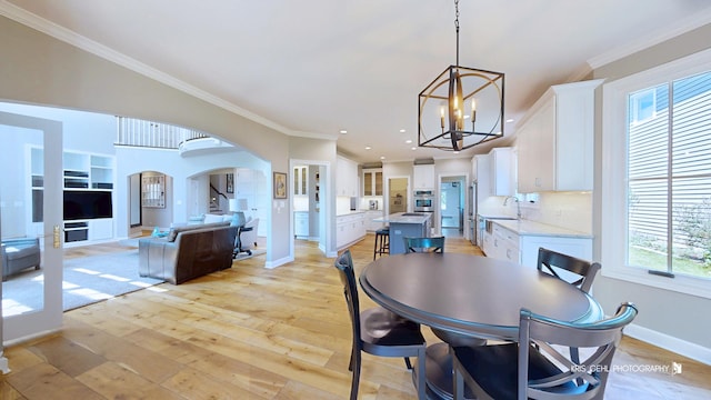 905 Burnham Ct, Aurora, IL 60502 - dining room with arched walkways, a chandelier, ornamental molding, light wood-style flooring, and recessed lighting