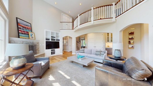 905 Burnham Ct, Aurora, IL 60502 - living area with arched walkways, a towering ceiling, stairs, wood finished floors, and recessed lighting