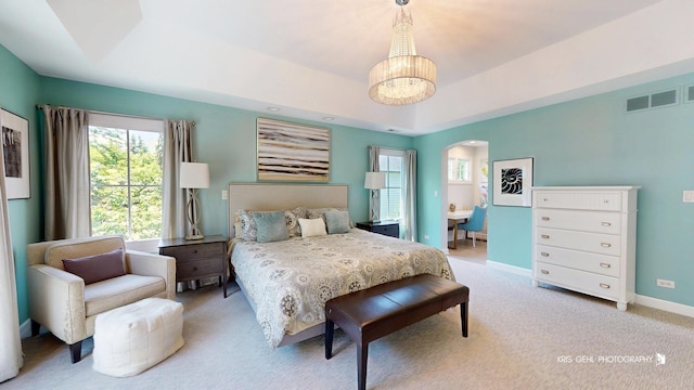 905 Burnham Ct, Aurora, IL 60502 - carpeted bedroom with arched walkways, a tray ceiling, and a chandelier