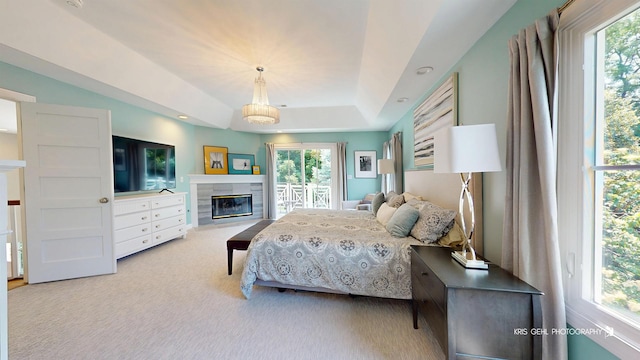 905 Burnham Ct, Aurora, IL 60502 - carpeted bedroom featuring multiple windows, a tiled fireplace, and a tray ceiling