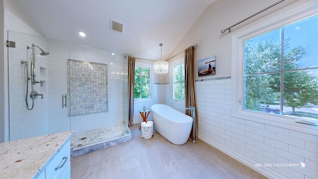 905 Burnham Ct, Aurora, IL 60502 - bathroom with a stall shower, lofted ceiling, a freestanding bath, tile walls, and vanity