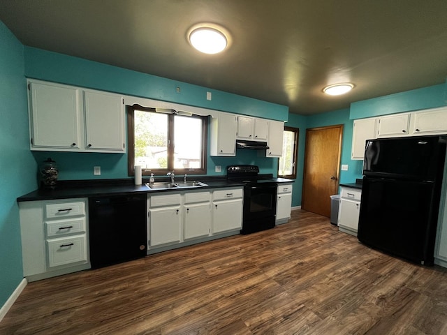 430 N 2nd St, Tonica, IL 61370 - kitchen featuring black appliances, under cabinet range hood, dark countertops, dark wood-type flooring, and white cabinetry