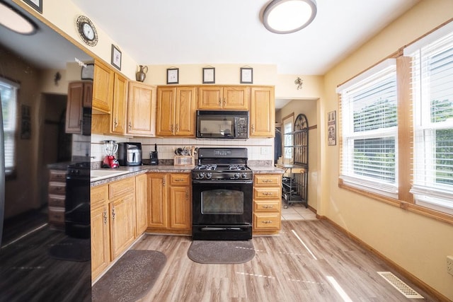 712 Mchenry Ave, Mchenry, IL 60050 - kitchen featuring black appliances, tasteful backsplash, light wood-type flooring, and light countertops