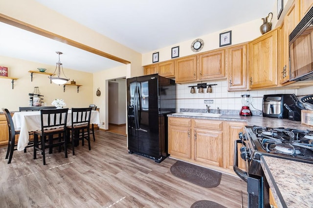 712 Mchenry Ave, Mchenry, IL 60050 - kitchen with black appliances, light wood-type flooring, backsplash, and pendant lighting