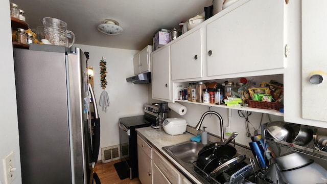 2637 Yeoman St, Waukegan, IL 60087 - kitchen featuring appliances with stainless steel finishes, under cabinet range hood, white cabinetry, wood finished floors, and open shelves