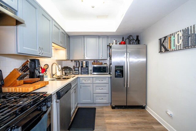 1461 N Winslowe Dr Unit 101, Palatine, IL 60074 - kitchen with appliances with stainless steel finishes, extractor fan, gray cabinets, and backsplash
