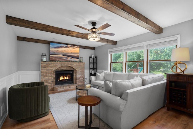 1297 Gregory Ct, Naperville, IL 60565 - living area featuring beamed ceiling, wood finished floors, a ceiling fan, a brick fireplace, and wainscoting