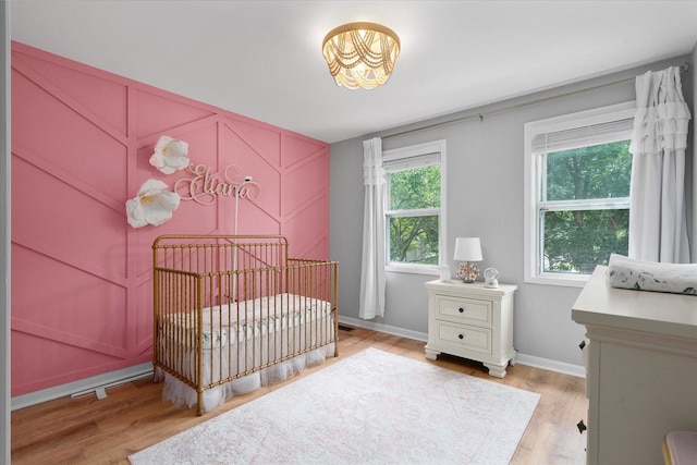 1297 Gregory Ct, Naperville, IL 60565 - bedroom featuring a crib, light wood-style floors, and a chandelier