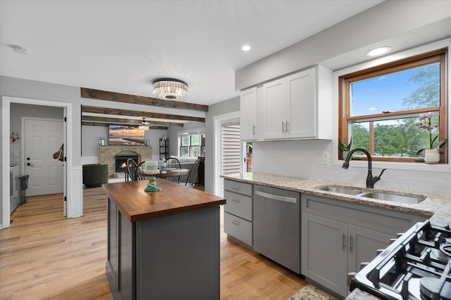 1297 Gregory Ct, Naperville, IL 60565 - kitchen with stainless steel appliances, butcher block countertops, tasteful backsplash, a lit fireplace, and gray cabinetry