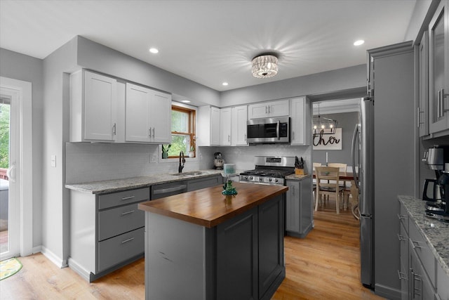 1297 Gregory Ct, Naperville, IL 60565 - kitchen featuring appliances with stainless steel finishes, butcher block countertops, a kitchen island, tasteful backsplash, and healthy amount of natural light