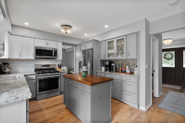1297 Gregory Ct, Naperville, IL 60565 - kitchen featuring appliances with stainless steel finishes, wood counters, gray cabinetry, decorative backsplash, and light wood finished floors