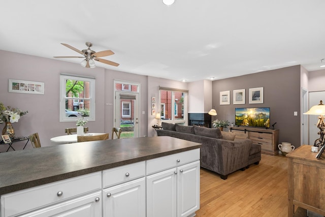 2809 N Wolcott Ave Unit H, Chicago, IL 60657 - kitchen featuring dark countertops, a ceiling fan, light wood-type flooring, and white cabinetry