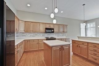3942 Honeymoon Rdg, Lake In The Hills, IL 60156 - kitchen with high quality fridge, black microwave, light wood-style floors, a kitchen island, and light countertops